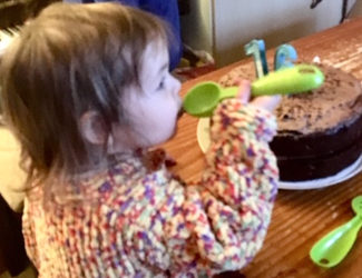 六月获奖海绵-孩子拿着绿色RAY竞技网站的勺子，背景是巧克力蛋糕。