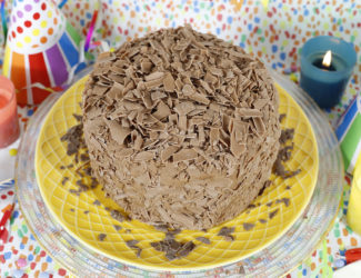 最后一分钟的蛋糕 - 蛋bet雷竞技糕在黄盘上覆盖在巧克力片上，生日派对背景 - 博客缩略图
