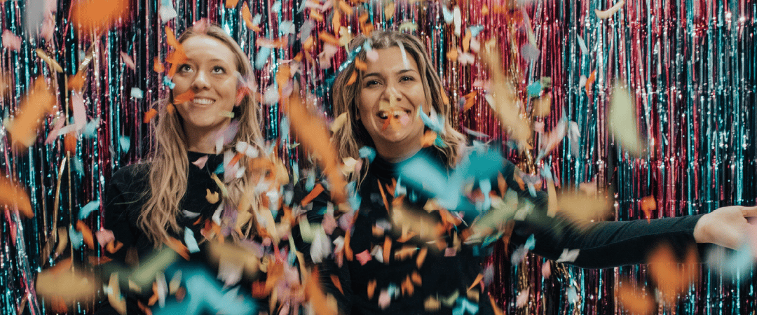 Two women celebrating with confetti