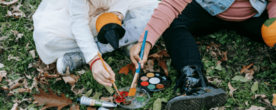 Children painting pumpkins outdoors
