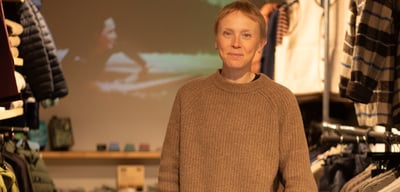 a women with fair short hair wearing a brown jumper