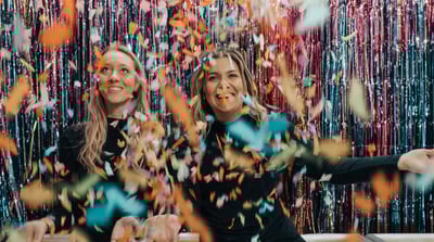 Two women celebrating with confetti